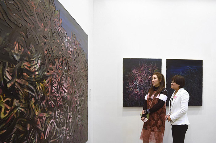 保利拍卖(澳门)CEO何超盈女士正在观摩唐华伟作品